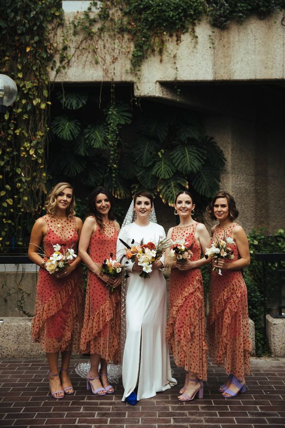 matching midi orange bridesmaid dresses with illusion necklines, ruffles and polka dot print