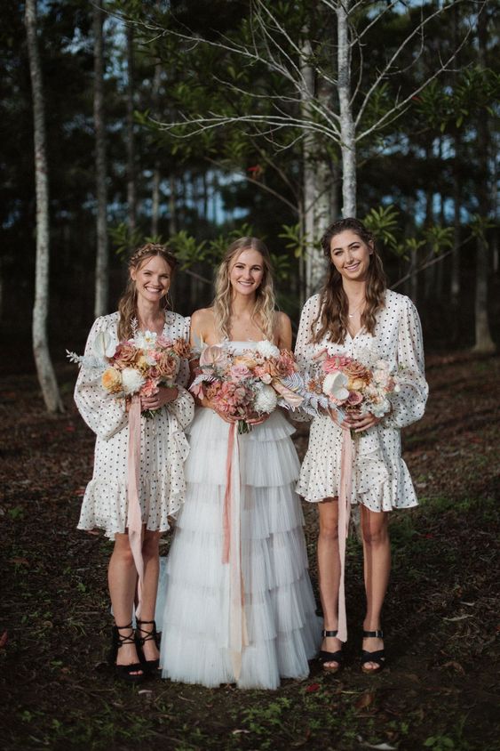 matching white polka dot knee bridesmaid dresses with ruffles and black shoes for a black and white wedding