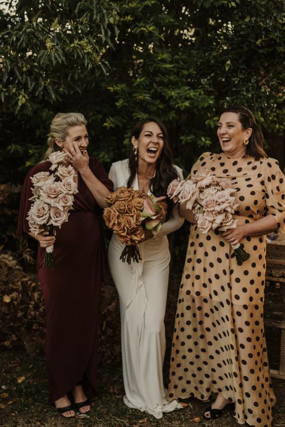 mismatched bridesmaid dresses, a burgundy and a yellow polka dot one plus black shoes for a fall wedding