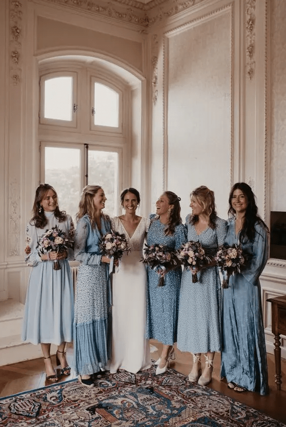 Mismatching dusty blue printed and non printed bridesmaid dresses of midi and maxi length, with long sleeves