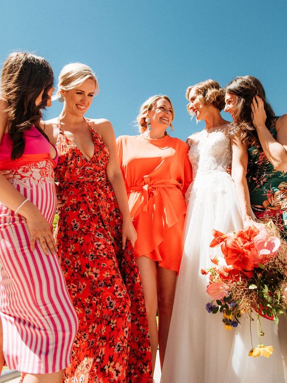 mismatching red and pink bridesmaid dresses with various prints are a bold and cool idea