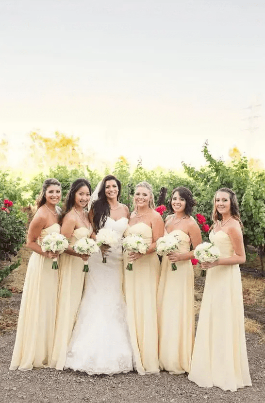 pale yellow strapless maxi bridesmaid dresses with draped bodices and pleated skirts are great for a spring wedding