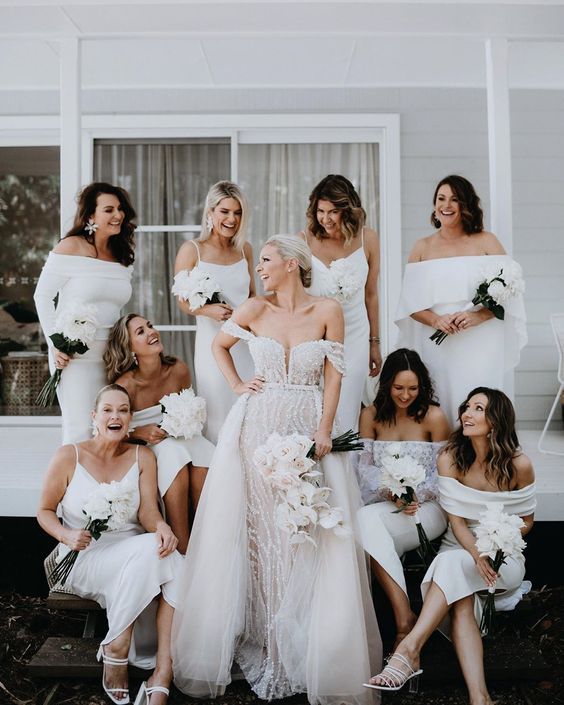 white spaghetti strap and off the shoulder midi bridesmaid dresses and white strappy shoes for a white wedding