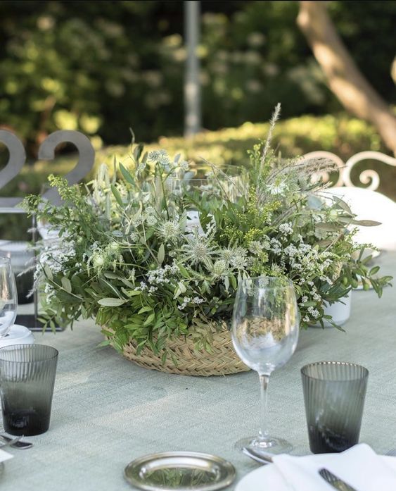 a basket filled with lots of textural greenery and some white blooms is a lovely idea for a fresh summer wedding