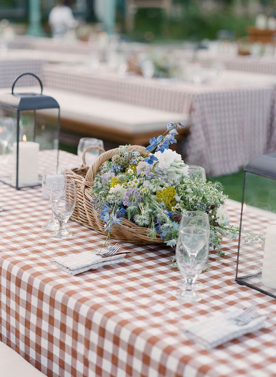 a basket wedding centerpiece of white, yellow and blue blooms and lots of greenery is a great idea for a summer wedding