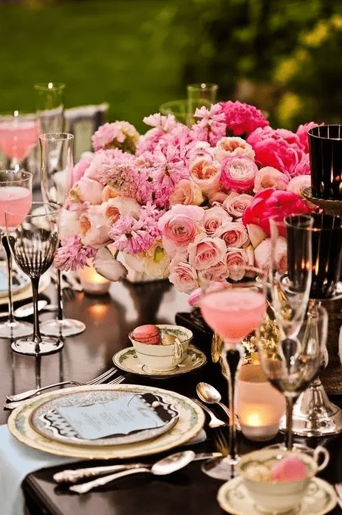 a beautiful and refined Valentine’s Day wedding table with printed plates, blush and hot pink blooms, gold touches and printed goblets