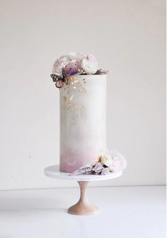 a blush ombre tall wedding cake with gold leaf, white and blush blooms and a butterfly is a lovely idea for spring or summer