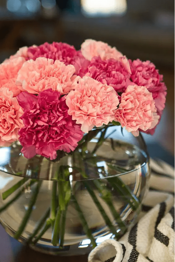 a bright and cool carnation wedding centerpiece of fuchsia and pink carnations in a clear bowl is a lovely idea