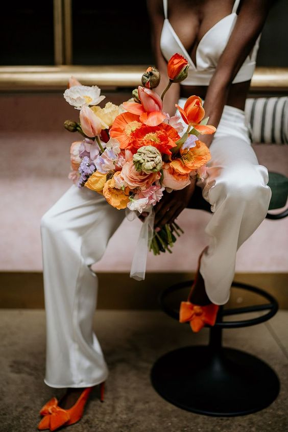 a bright spring wedding bouquet of orange tulips, poppies, pink roses and sweet peas is a lovely and chic solution