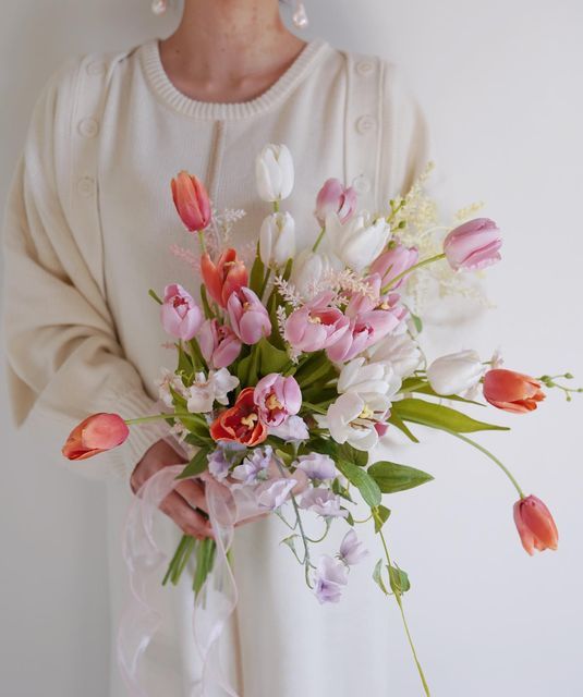 a bright spring wedding bouquet of pink, orange and white tulips plus sweet peas is a cool idea for a casual spring bride