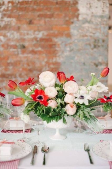 a bright wedding centerpiece of neutral ranunculus, peony roses and red tulips and anemones is perfect for a Valentine’s Day wedding