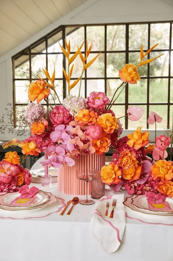 a bright wedding centerpiece of various shades of pink, orange, blush and marigold flowers is amazing for summer