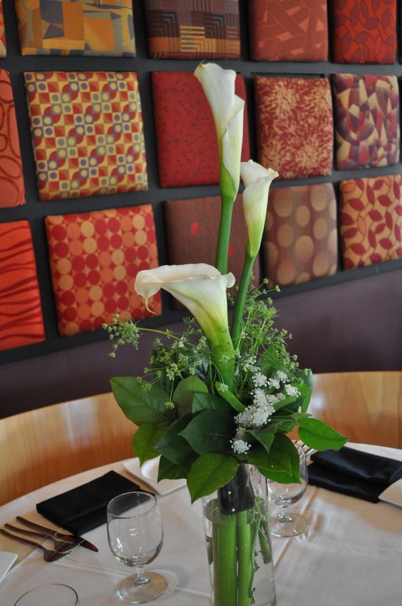 a catchy wedding centerpiece of white callas, greenery and some fillers is a stylish idea for a modern wedding
