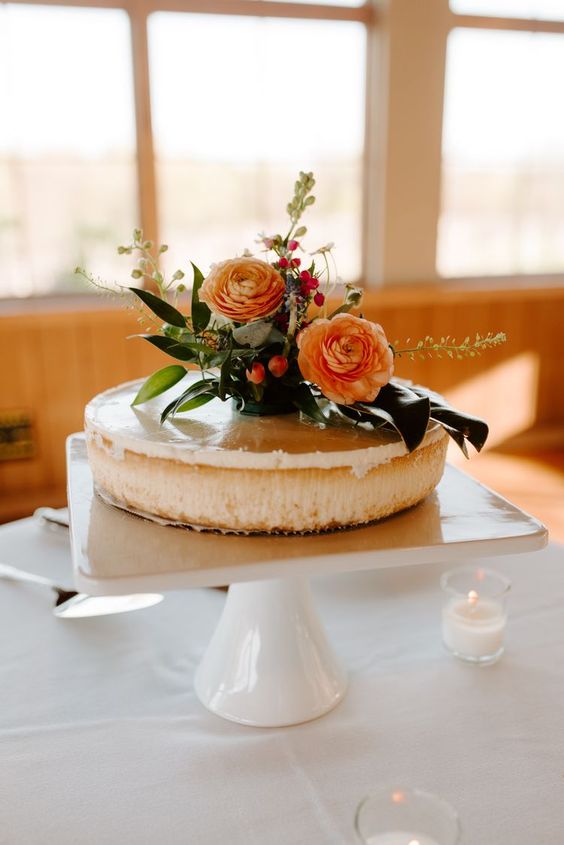 a cheesecake with fresh blooms and greenery is always a good idea for a wedding, perfect for those who don’t like sweets
