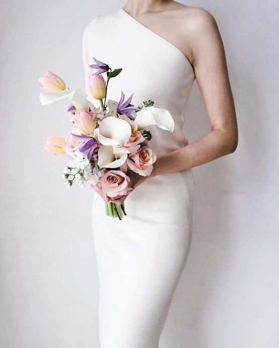 a chic modern wedding bouquet of pink roses, white callas, purple blooms and pink tulips is ideal for spring or summer