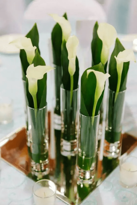 a chic wedding centerpiece of a mirror with glasses and a single calla lily in each is amazing for an elegant wedding