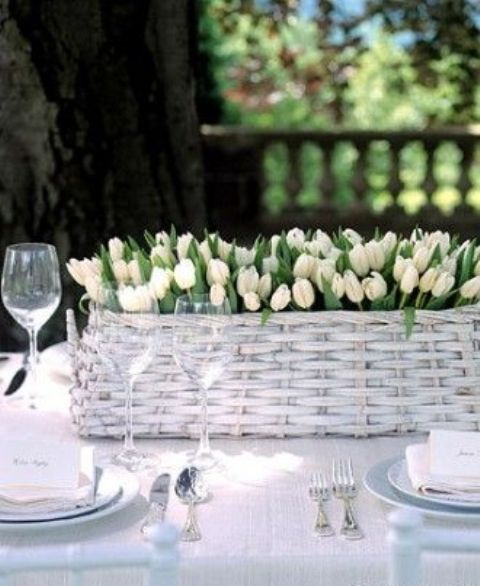 a classy whitewashed basket wedding centerpiece with only white tulips is amazing for a neutral spring wedding