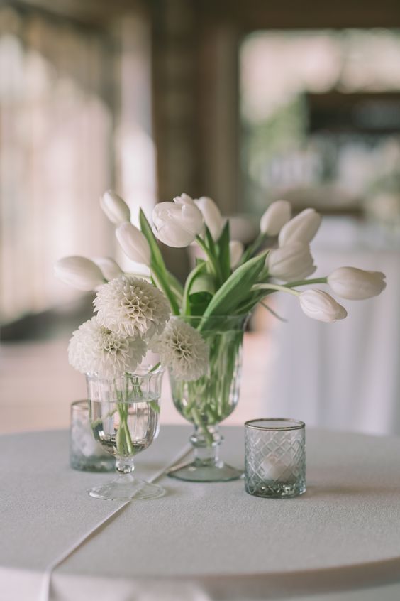 A cluster wedding centerpiece of mums and tulips in white is a cool idea for an all white wedding or just a neutral spring one