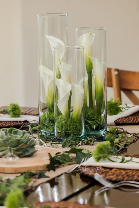 a cluster wedding centerpiece of vases with moss and callas inside them is a super creative and bold idea