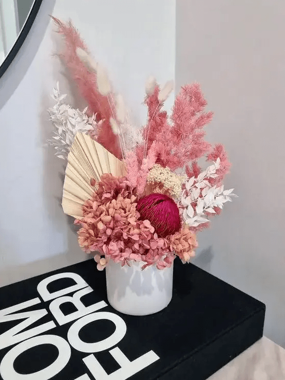 a colorful dried flower wedding centerpiece with hydrangeas, fronds, leaves and pampas gras splus bunny tails will make a statement with its color