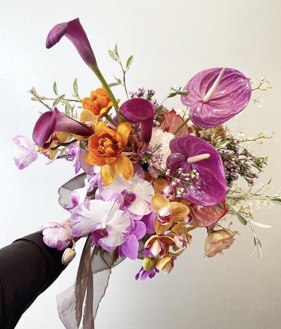 a colorful wedding bouquet of orange and hot pink orchids, hot pink callas and anthuriums, some fillers is a cool idea for summer