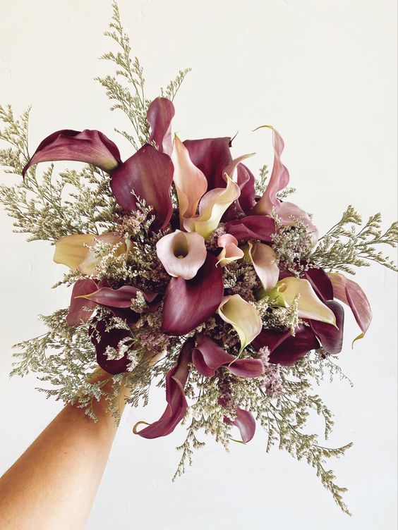 a contrasting wedding bouquet of white and purple callas and some fillers is a cool and chic idea fro a fall wedding