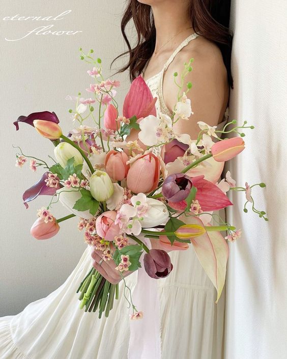 a cool bright wedding bouquet of pink and purple callas and tulips, white and pink tulips, some orchids and greenery
