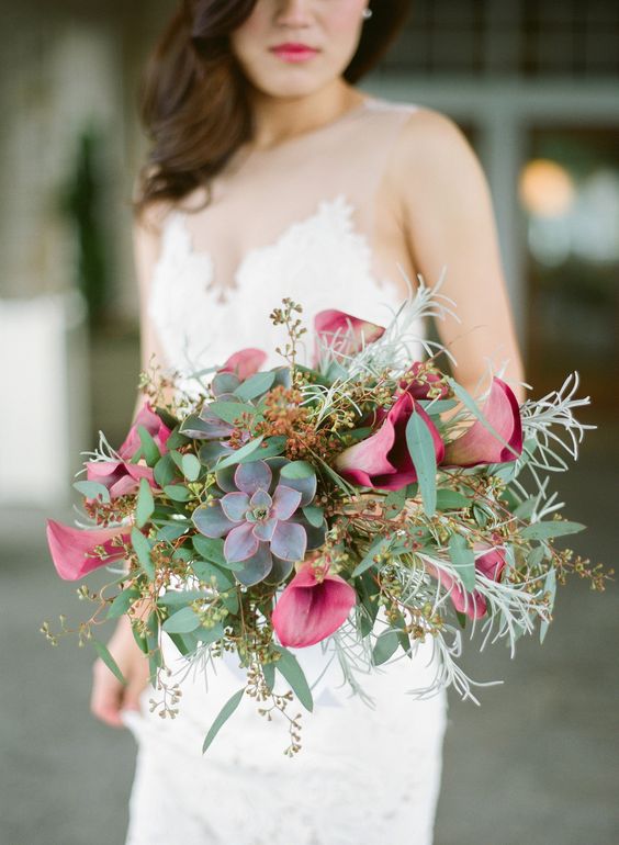 a fall wedding bouquet of pink callas, dark succulents, berries and seeded eucalyptus is adorable