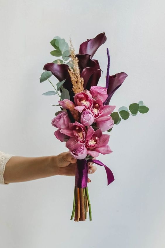 a fall wedding bouquet of purple callas, pink orchids and some eucalyptus for a modern fall bride