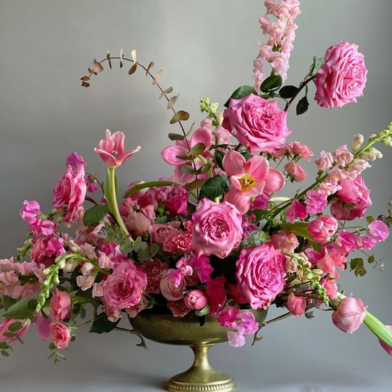 a fantastic dimensional wedding centerpiece of pink roses, orchids, delphinium and greenery for a pink wedding