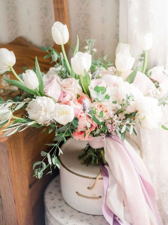 a fantastic spring wedding bouquet of white tulips, white and pink roses and waxflowers plus greenery is amazing