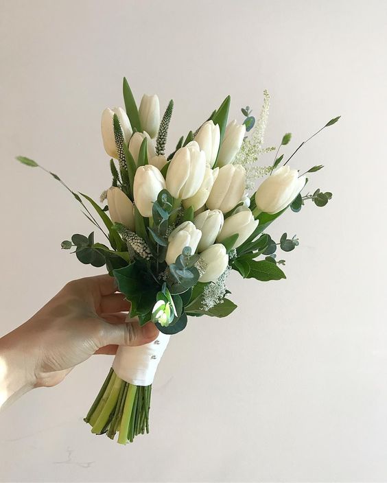 a fresh spring wedding bouquet of white tulips and astilbe plus greenery will work for a modern or minimalist spring bride