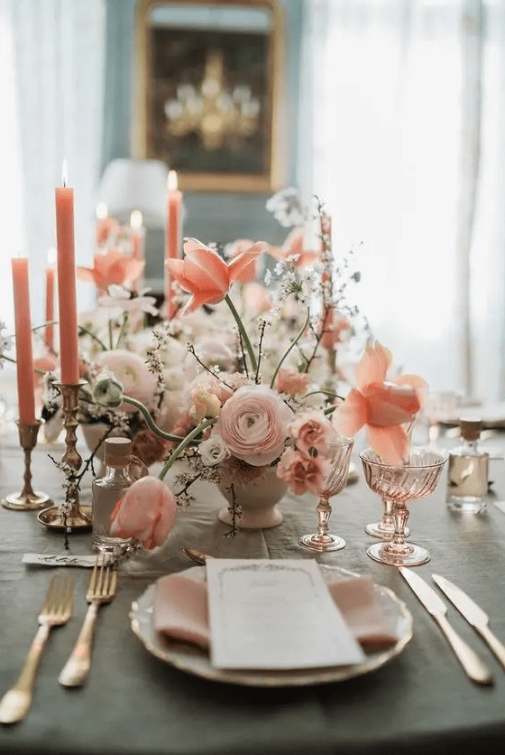 a gorgeous pink wedding centerpiece with ranunculus, peachy tulips and some pink carnations is absolutely adorable