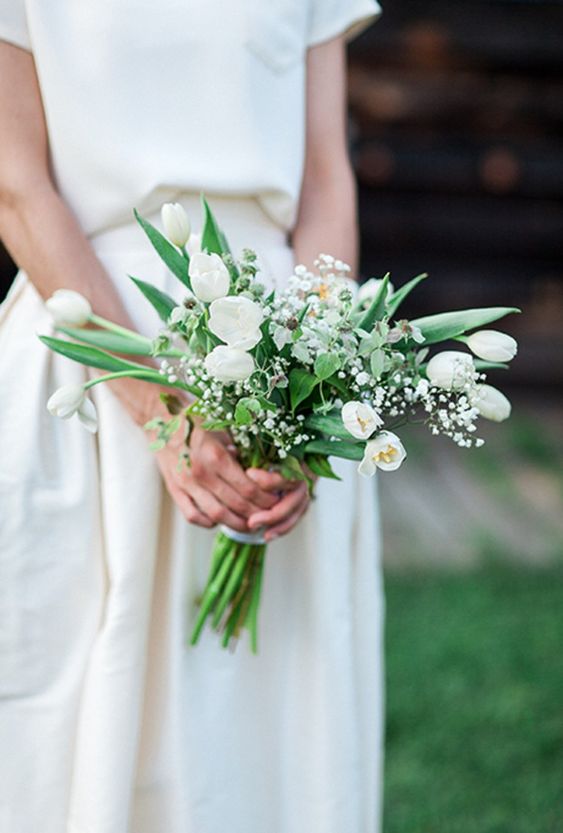 a lovely and airy wedding bouquet of white tulips, baby's breahth and some foliage foer a casual spring bride