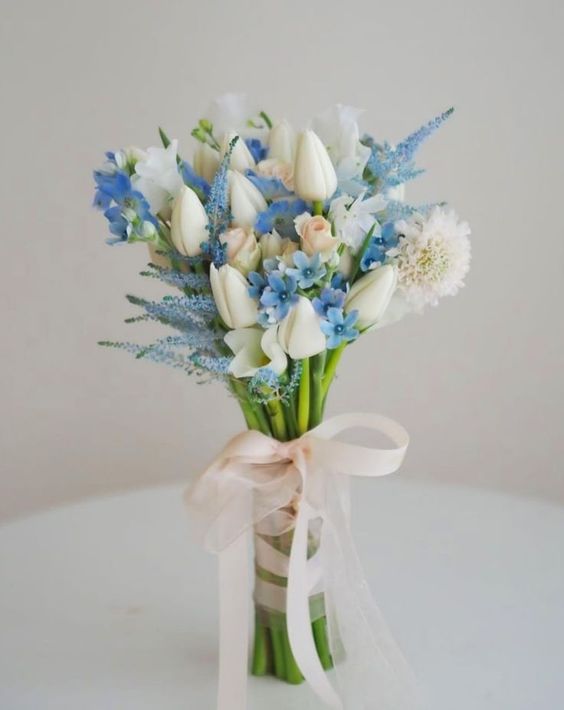 a lovely spring wedding bouquet of white tulips and various kinds of blue flowers is a super cool idea if you want ‘something blue’
