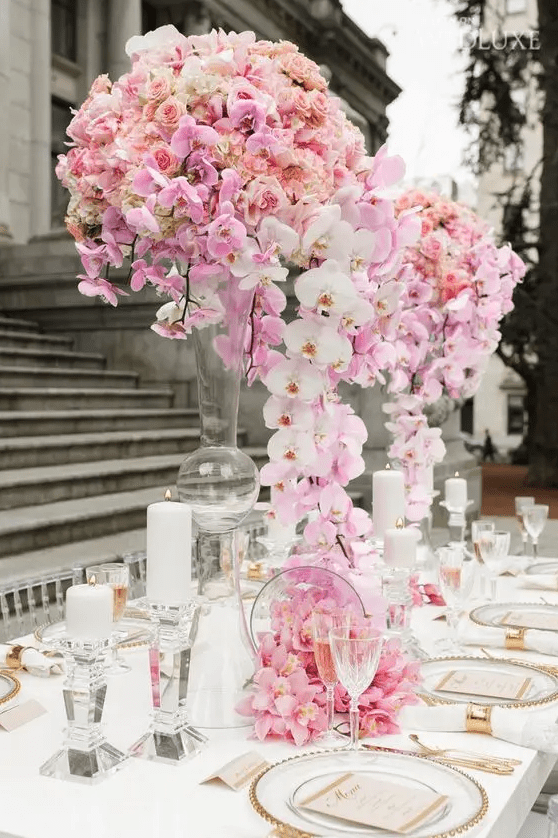 a lush and refined pink and blush floral wedding centerpiece on tall stands is very spectacular and it looks wow