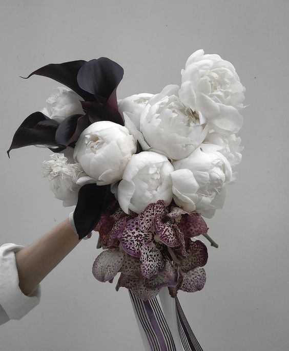 a moody fall wedding bouquet of white peonies, purple orchids and deep purple callas for a modern wedding