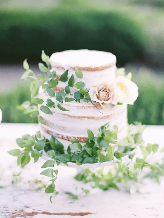 a naked cake with fresh foliage and a couple of neutral blooms will be a great and lovely idea for a spring or summer wedding