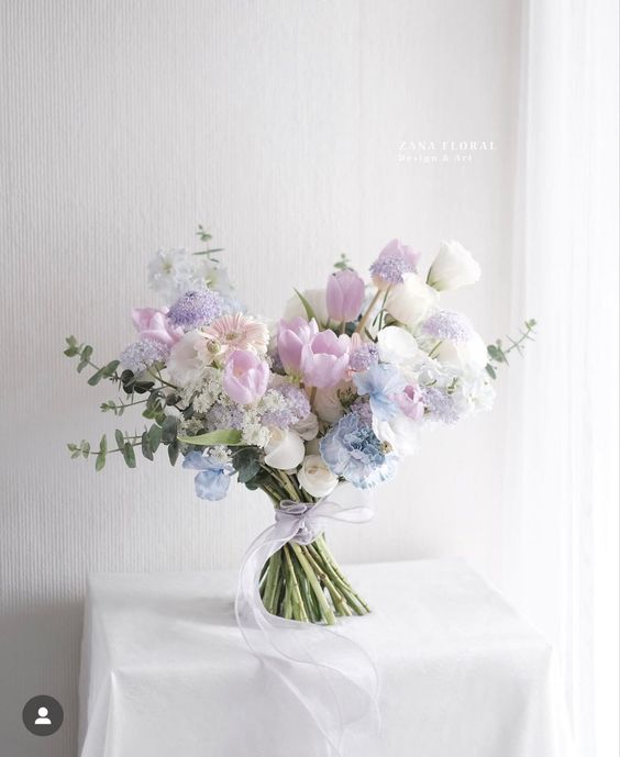 a pastel wedding bouquet of lilac tulips, white roses, blush gerberas, greenery and some fillers is a lovely idea for spring