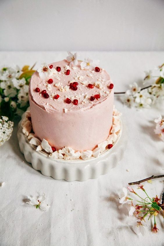 a pink wedding cake topped with pomegranate, cherry blossom and nuts is a chic and delicious idea for spring