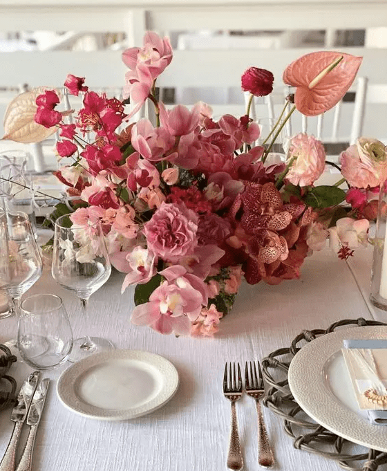a pink wedding centerpiece of orchids, carnations, ranunculus and anthurium is a fantastic idea