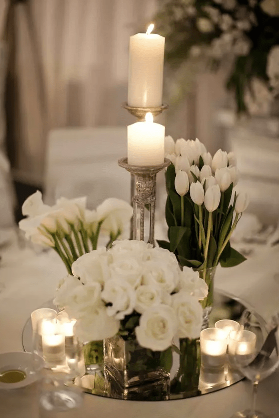 a refined modern wedding centerpiece of white callas, tulips and roses plus candles around is amazing for neutral weddings