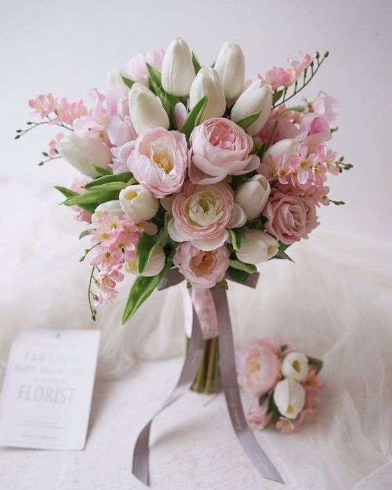a refined spring wedding bouquet of pink ponies, white tulips and pink cherry blossom plus some greenery