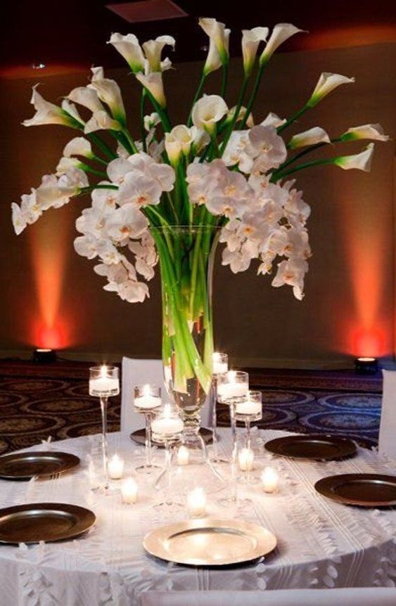 a refined tall wedding centerpiece of white callas and orchids is a chic and bold idea that will fit many wedding styles