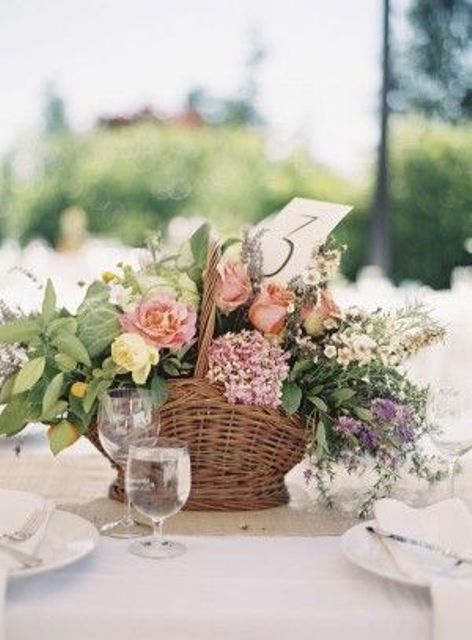 a rustic wedding centerpiece of pink and yellow roses, purple and pink fillers and greenery is a cool idea for summer