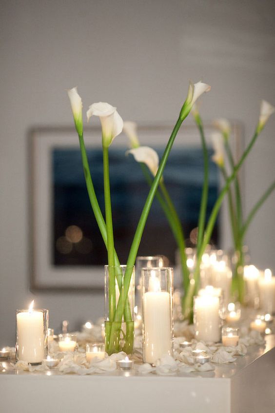 a simple and minimal wedding centerpiece of white callas in clear vases are cool for a modern or minimalist wedding