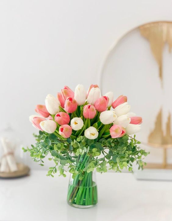 a simple tulip wedding centerpiece of pink and white tulips and some greenery can be easily repeated without any florists’ help