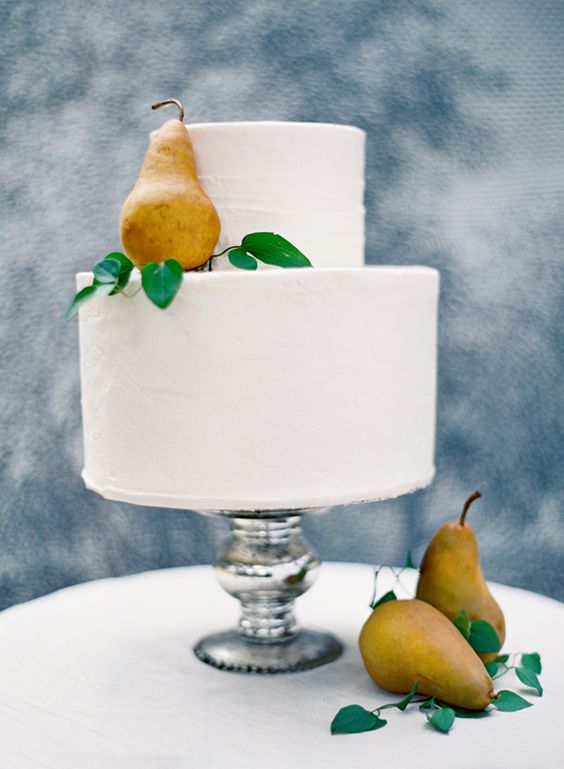 a simple white wedding cake topped with fresh pears and greenery is a lovely and tasty solution for the fall