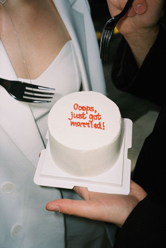 a small white wedding cake with red letters is a cool and very modern idea suitable for a small wedding