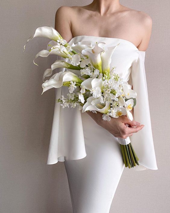 a sophisticated modern white wedding bouquet of callas and some white fillers is a stylish idea for a modern or minimalist bride